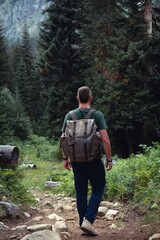 Wall Mural - Male hiker with retro backpack. A tourist walks along a mountain path in the middle of the forest. Front view. A gloomy summer day. Georgia. the way to the Shdugra waterfall