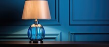 A Trendy Color Scheme For Your Interior Includes A Blue Lampshade And A Table Lamp With A Glass Element Near A Light Wall All Complemented By A Grey Cloth