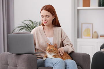 Canvas Print - Woman with cat working in armchair at home