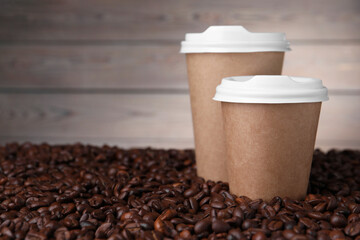 Canvas Print - Coffee to go. Paper cups on roasted beans, closeup. Space for text