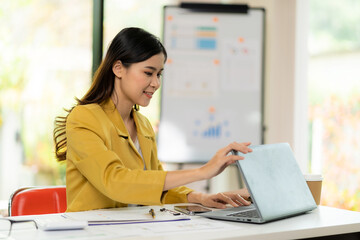 Wall Mural - Analytical research concept, Asian woman using calculator and laptop to do finance, mathematics on office table, taxes, reports, accounting, statistics.