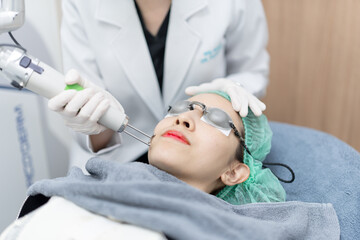 Wall Mural - Woman receiving pico laser facial treatment in beauty Clinic.