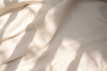 Closeup Of Crumpled Beige Silk Fabric With Natural Light With Shadow From Window. High Quality Photo