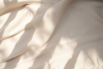 Closeup of crumpled beige silk fabric with natural light with shadow from window. High quality photo