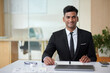 © DragonImages - Portrait of cheerful young entrepreneur working at office desk