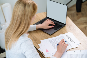  Woman looking for information on laptop and signing contract