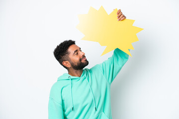 Wall Mural - Young Brazilian man isolated on white background holding an empty speech bubble