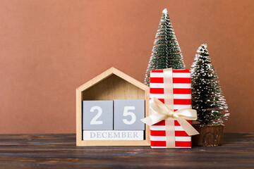 Wall Mural - 25 december. Christmas composition on colored background with a wooden calendar, with a gift box, toys, bauble copy space