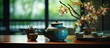 In a Japanese setting an Asian tea pot sits elegantly on a wooden table adorned with a vibrant flower arrangement creating a serene backdrop The concept of using chopsticks to enjoy delicat