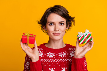 Wall Mural - Portrait of lovely positive woman with stylish hairdo wear ornament sweater hold two small gift boxes isolated on yellow color background