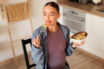 Wall Mural - Pregnant woman enjoying a healthy meal, savoring every bite