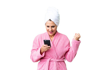 Canvas Print - Middle age caucasian woman in a bathrobe over isolated background surprised and sending a message