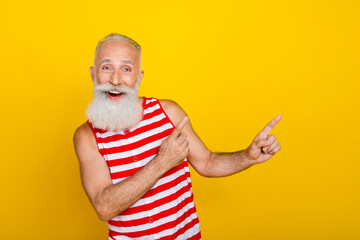 Sticker - Photo of funky excited senior man wear red striped swimsuit pointing two fingers empty space isolated yellow color background