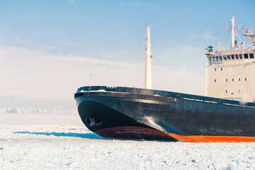 Winter shipping. Big cargo ship in frozen ice sea