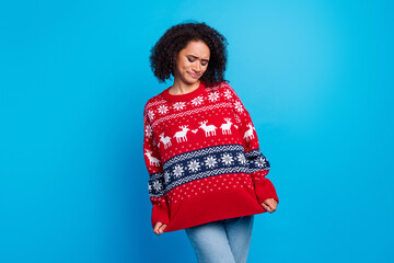 Sticker - Photo of young girl grimace and showing her oversize ugly sweater which she wearing every christmas isolated on blue color background