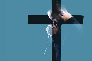 Wall Mural - Believing man prays with silhouette Christian cross