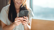 © oatawa - Close-up shot of an Asian woman using her smartphone, texting and chatting on messengers, buying online, reading books, articles.