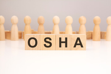 Wall Mural - OSHA - word composed from wooden blocks letters on white background, copy space for text