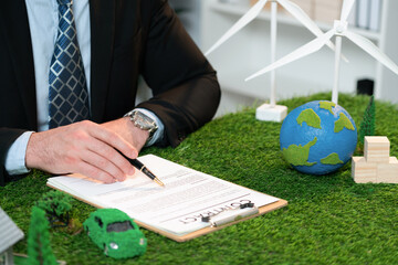 Businessman or CEO in office signing environmental regulation agreement to save Earth with sustainable energy utilization and CO2 reduction for greener future. Quaint