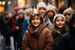 Smiling boy in crown among large group of people with children on the street waiting for the Three Kings to appear in the parade. Three Kings Day, Epiphany day.