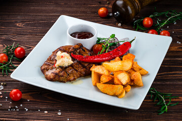 Sticker - Fried pork fillet steak with Rustic fried potato wedges, onions, chili peppers, cherry tomatoes and sauce, lunch.