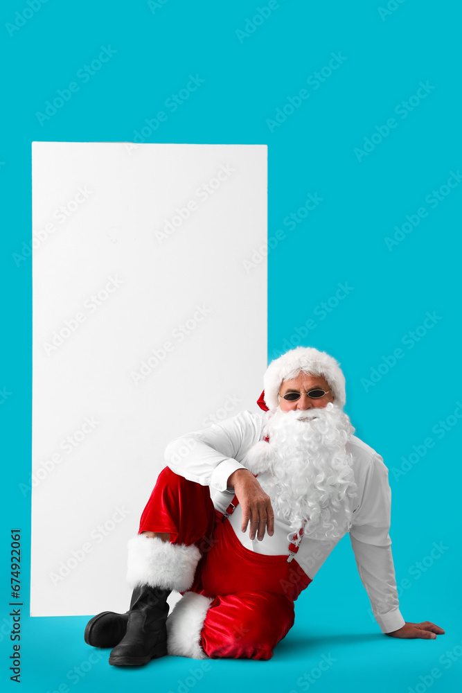 Cool Santa Claus with blank poster on blue background