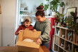 © Davor - Young mother surprising her son with gift in box at home