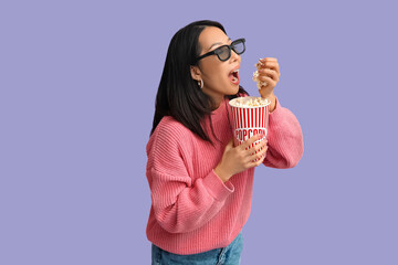 Poster - Young Asian woman in 3D glasses with bucket of popcorn on purple background