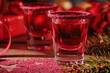 Cranberry vodka shot and Christmas decorations on wooden background. Winter holidays concept.