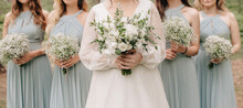 Bridesmaids and bride holding wedding bouquets of white flowers