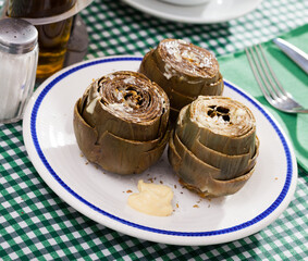 Wall Mural - Steamed artichokes sprinkled with koshering salt served with Mediterranean sauce aioli. Concept of vegetarian food..