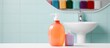 In the background of the white isolated bathroom a colorful bottle made of plastic holds a liquid chemical detergent serving as a domestic hygiene product