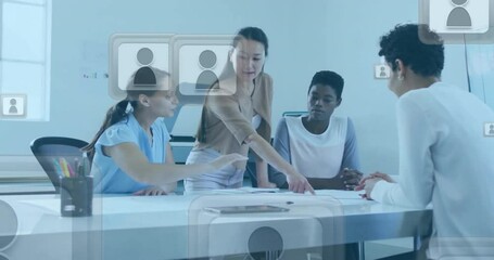 Wall Mural - Animation of profile icon in squares over diverse female coworkers discussing reports in office