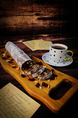 Wall Mural - Wooden cutting board with a healthy sweet roll and a cup of coffee and paper letters on the table