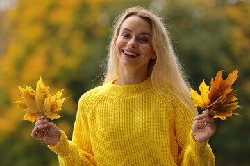 Canvas Print - Portrait of happy woman with autumn leaves outdoors