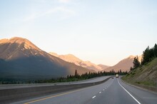 Open Road With Golden Mountains In The Background During Early Morning In Canada