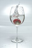 Fototapeta Paryż - Ripe red strawberry is displayed in a wine glass, with water droplets