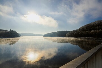 Canvas Print - Beautiful sunrise over a tranquil lake, with reflections of the sun glistening