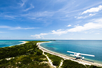 Poster - Aerial view of a grass covered beach with a water airplane parked on the shoreline