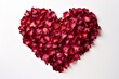 A heart-shaped composition crafted from crimson rose petals set against a white backdrop