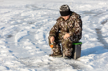 Sticker - A boy fishes in the snow in winter