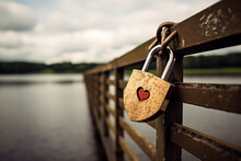 A Heart-shaped Lock Attached To A Bridge, Symbolizing A Lasting Love, With Names Or Initials Engraved On It.