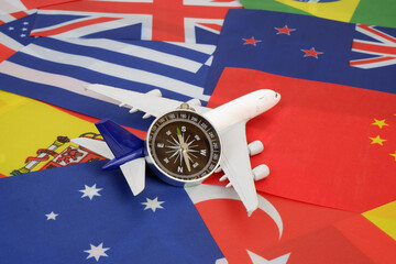 Compass and airplane on national flags background. Tourism and travel direction concept.