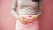 sad young woman holding her stomach, illness, cramps, health, color background, girl suffering, painful periods, stomach-ache, abdominal, griping, bellyache, tummy-ache, gripes, portrait, ill, pastel