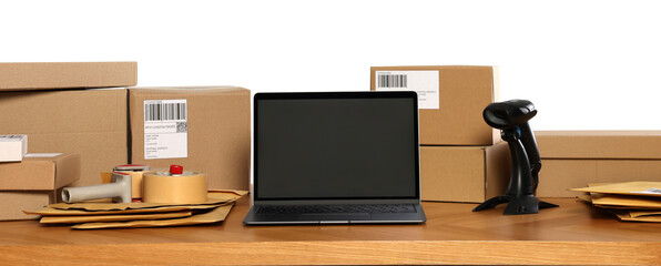 Canvas Print - Parcels, laptop and barcode scanner on wooden table against white background. Online store