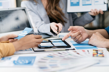 Creative team web designer planning application development for web mobile phone with customer breif and color code at office.