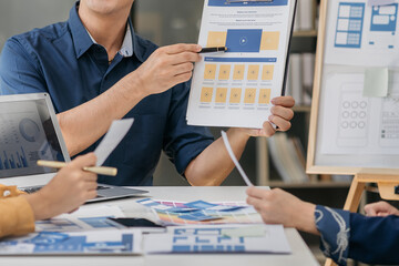 Creative team web designer planning application development for web mobile phone with customer breif and color code at office.