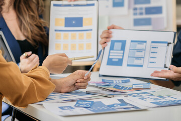 Creative team web designer planning application development for web mobile phone with customer breif and color code at office.
