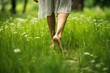 Woman walking barefoot on green grass outdoor, close-up.