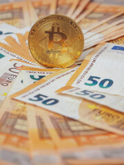 Golden bitcoin standing on euro bank notes. Time to invest into crypto currency concept. Economy and financial background. Get rich theme.